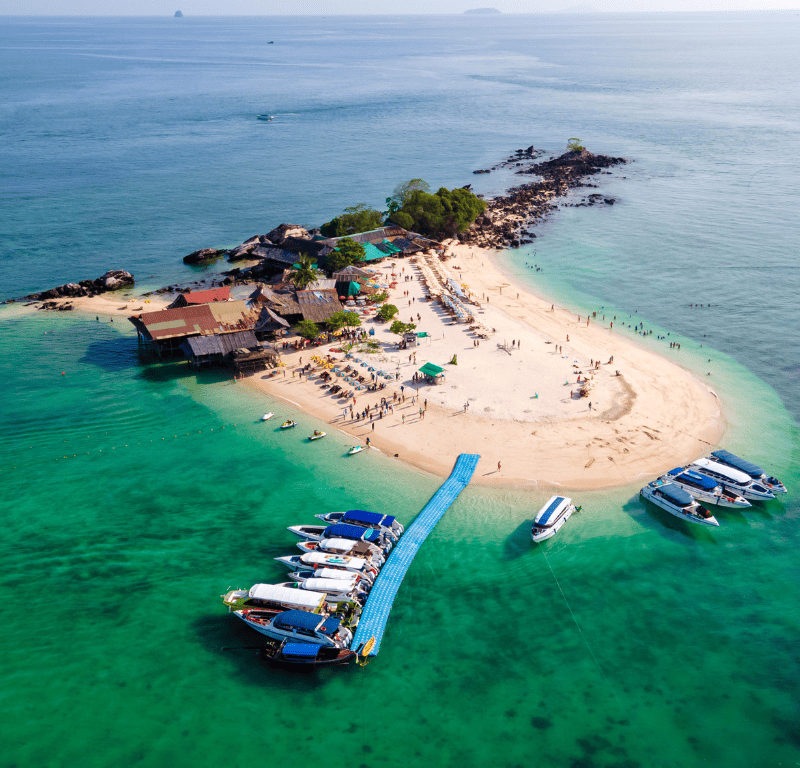 Drone shot of the boats parking next to khai island and the restaurant roof in view.